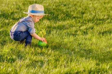 yürümeye başlayan çocuk hasır şapka ve holding sulama giyiyor olabilir