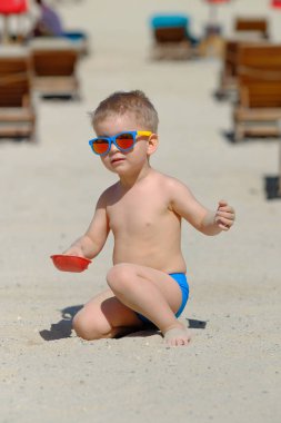 Kumsalda eğleniyor iki yaşında bir yürümeye başlayan çocuk 