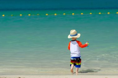 Kumsalda eğleniyor iki yaşında bir yürümeye başlayan çocuk 