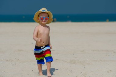 Kumsalda eğleniyor iki yaşında bir yürümeye başlayan çocuk 