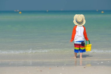 Kumsalda eğleniyor iki yaşında bir yürümeye başlayan çocuk 