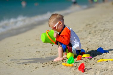 Kumsalda eğleniyor iki yaşında bir yürümeye başlayan çocuk 