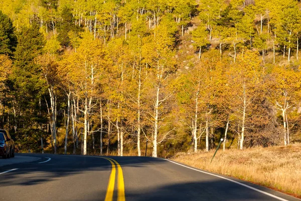 Highway at autumn sunny day in Rocky Mountain National Park, Colorado, USA.