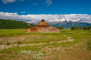 Alçak bulutlar ile eski mormon ahır Grand Teton Dağları'nda. Grand Teton Milli Parkı, Wyoming, ABD.