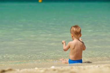 Sahilde iki yaşında bir yürümeye başlayan çocuk 