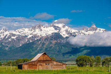 Alçak bulutlar ile eski mormon ahır Grand Teton Dağları'nda. Grand Teton Milli Parkı, Wyoming, ABD.