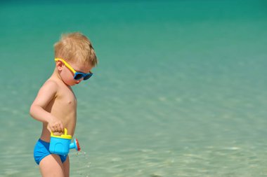 yürümeye başlayan çocuk oyuncakları ile kumsalda oynarken 