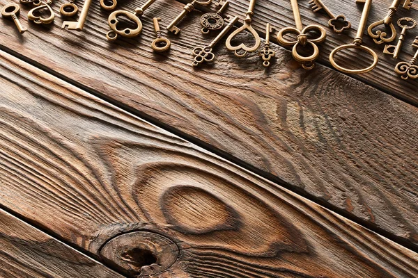 木桌背景上的各种金属钥匙 — 图库照片