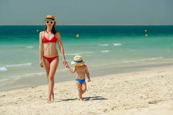 Милый Малыш Прогуливаясь Матерью Шляпах Пляже Чистой Голубой Водой — стоковое фото