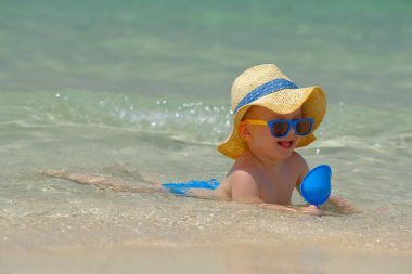 Sahilde plaj oyuncakları ile oynarken iki yaşında bir yürümeye başlayan çocuk 