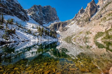 Zümrüt Gölü ve sonbaharda etrafındaki kayalar ve dağlarla yansıması. Colorado, ABD 'deki Rocky Dağı Ulusal Parkı. 
