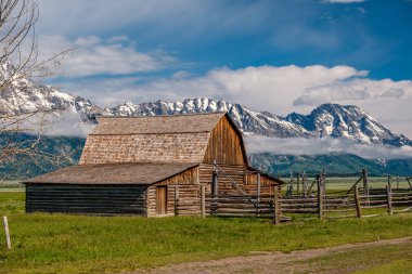 Alçak bulutlar ile eski mormon ahır Grand Teton Dağları'nda. Grand Teton Milli Parkı, Wyoming, ABD.
