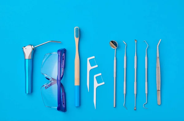 파란색 배경 위에 있는 치과용 도구들 — 스톡 사진