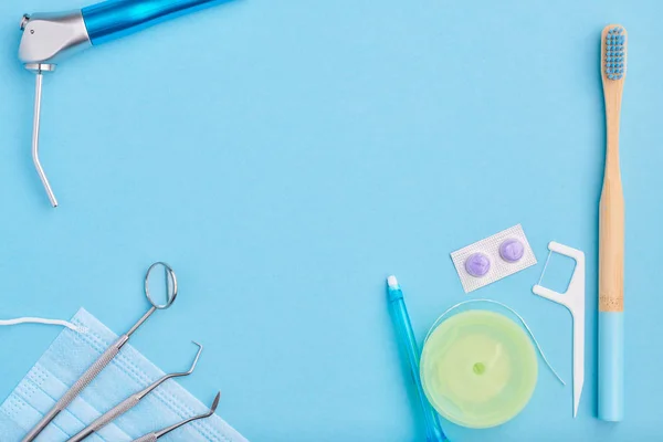 Herramientas dentistas sobre fondo azul vista superior — Foto de Stock