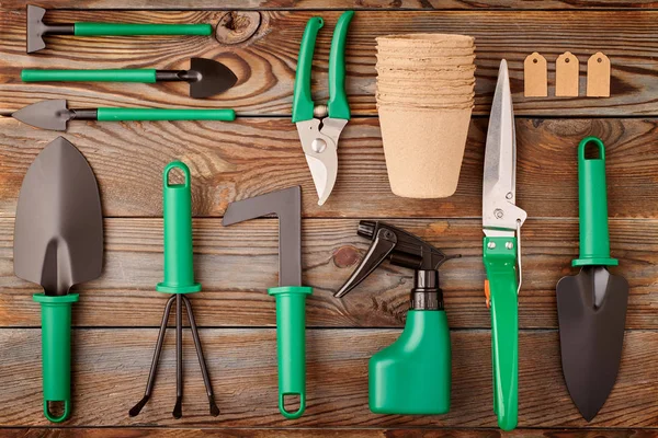 Εργαλεία κηπουρικής σε ξύλινη επίπεδη φόντο lay — Φωτογραφία Αρχείου
