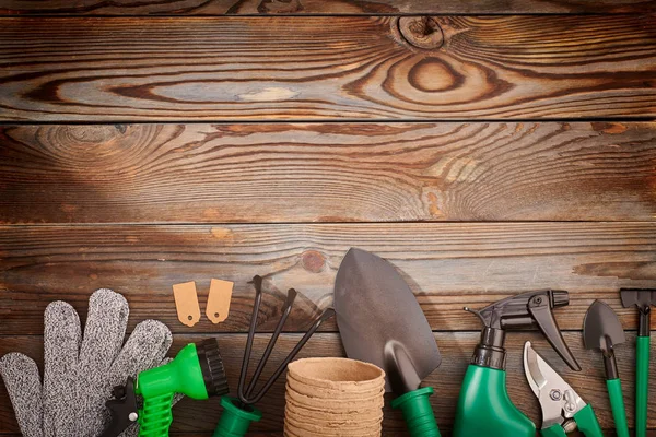 Herramientas de jardinería sobre fondo de madera planas —  Fotos de Stock