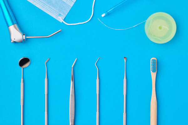 Dentist tools over blue background top view