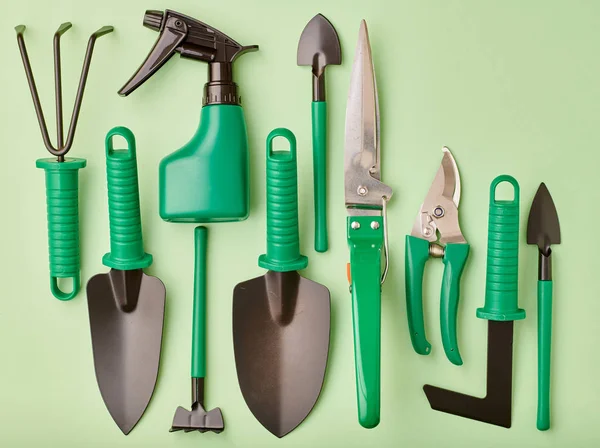 Gardening tools on green background flat lay — ストック写真