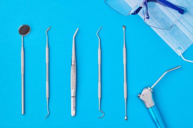 Dişçi araçları mavi arkaplan üst görünüm düz yatıyordu. Diş bakımı, diş hijyeni ve sağlık konsepti. 