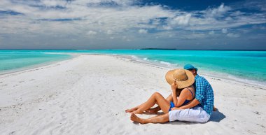 Maldivler 'de tropik bir plajda mavi elbiseli çift.