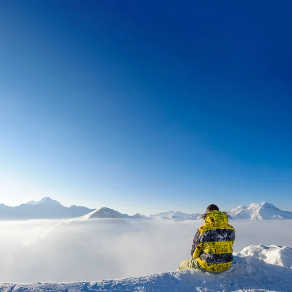 Alpejski Zimowy Krajobraz Górski Człowiekiem Siedzącym Nad Niskimi Chmurami Alpy — Zdjęcie stockowe