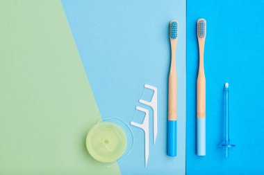 Diş fırçaları ve oral bakım araçları mavi arka plan üst görünüm fotokopi alanı düzlüğü üzerinde. Diş bakımı, diş hijyeni ve sağlık konsepti. 