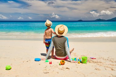 Babasıyla plajda üç yaşında küçük bir çocuk. Seyşeller 'de yaz tatili, Mahe..