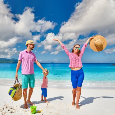 Güzel Anse Soleil plajında bir aile, üç yaşında bir çocuğu olan genç bir çift. Seyşeller 'de yaz tatili, Mahe..