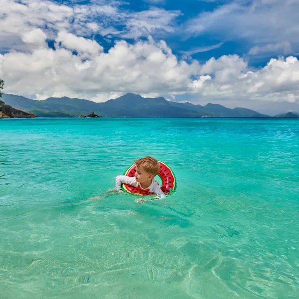 塞舌尔海滩上3岁的小男孩带着充气环游泳 — 图库照片