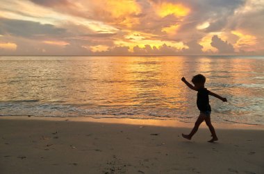 Three year old toddler boy walking on beach at sunset. Summer family vacation at Seychelles, Mahe.