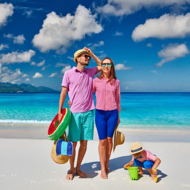 Güzel Anse Soleil plajında bir aile, üç yaşında bir çocuğu olan genç bir çift. Seyşeller 'de yaz tatili, Mahe..