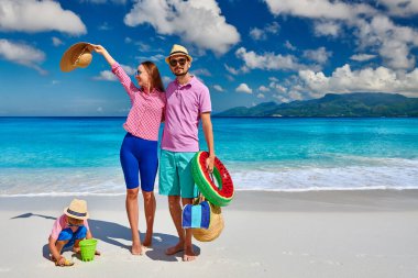 Güzel Anse Soleil plajında bir aile, üç yaşında bir çocuğu olan genç bir çift. Seyşeller 'de yaz tatili, Mahe..