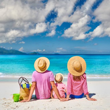 Güzel Anse Soleil plajında bir aile, üç yaşında bir çocuğu olan genç bir çift. Seyşeller 'de yaz tatili, Mahe..