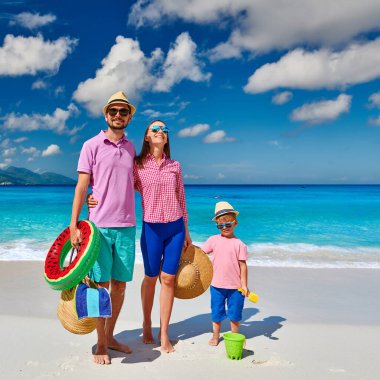 Güzel Anse Soleil plajında bir aile, üç yaşında bir çocuğu olan genç bir çift. Seyşeller 'de yaz tatili, Mahe..