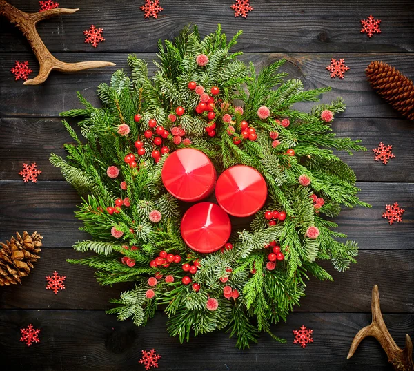 暗い素朴な木製の背景にクリスマスリースとキャンドル — ストック写真