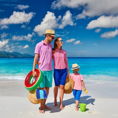 Güzel Anse Soleil plajında bir aile, üç yaşında bir çocuğu olan genç bir çift. Seyşeller 'de yaz tatili, Mahe..