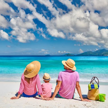 Güzel Anse Soleil plajında bir aile, üç yaşında bir çocuğu olan genç bir çift. Seyşeller 'de yaz tatili, Mahe..