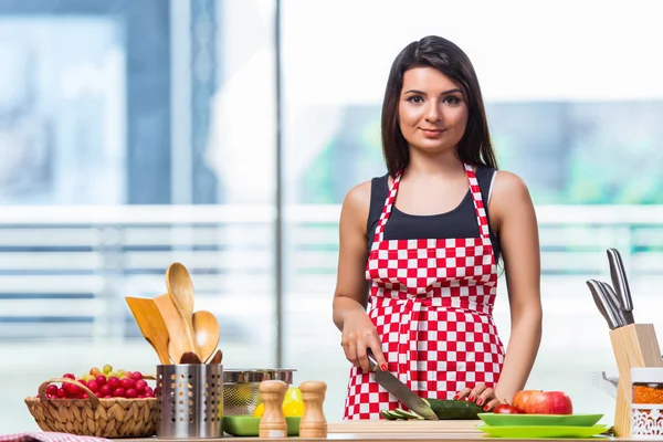 Ung kvinna förbereda sallad i köket — Stockfoto