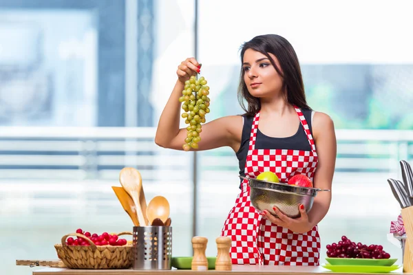 Jovem cozinheiro com frutas na cozinha — Fotografia de Stock