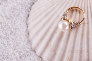 Altın yüzük ve deniz kabuğu