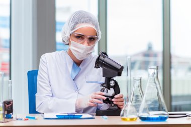 Genç öğrenci laboratuarında kimyasal çözümleri ile çalışma