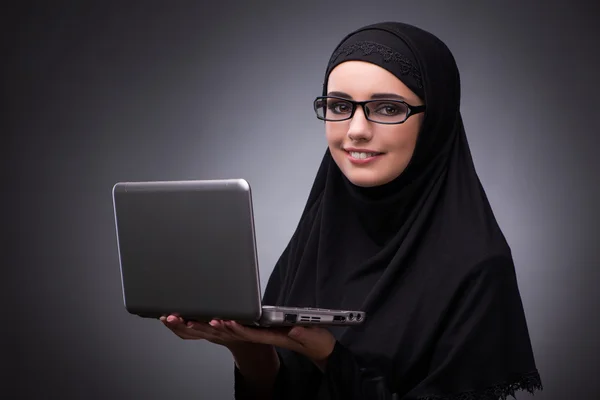Muslim woman in black dress against dark background — Stock Photo, Image