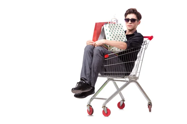 Young man with shopping cart and bags isolated on white — Stock Photo, Image