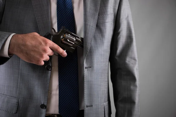 Homem a tirar a arma do bolso — Fotografia de Stock