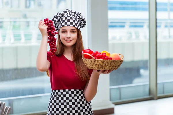 Молодой повар с фруктами на кухне — стоковое фото