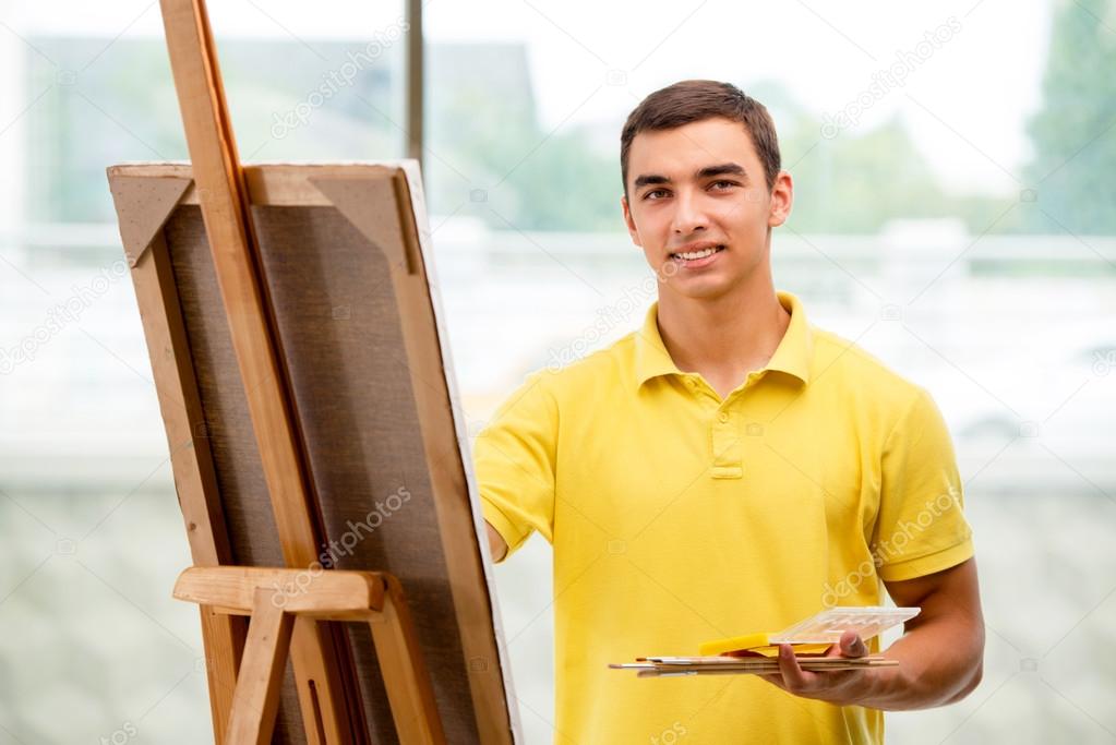 Young male artist drawing pictures in bright studio