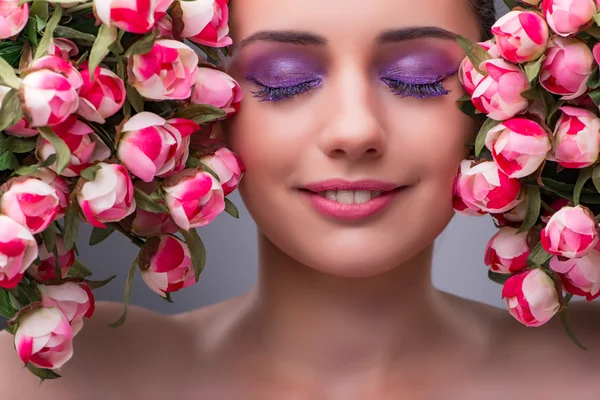 Ung kvinna med blommor i skönhet koncept — Stockfoto
