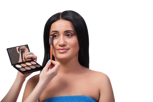 Mujer joven consiguiendo maquillaje aislado en blanco — Foto de Stock