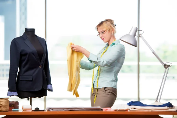 Mujer sastre trabajando en ropa nueva — Foto de Stock