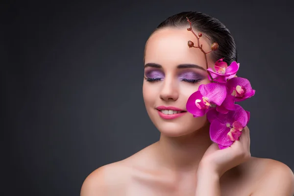 Giovane bella donna con fiore di orchidea — Foto Stock